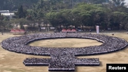 Participants form a female symbol as part of celebrations for International Women's Day in Manila (March 8, 2014.) 