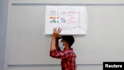 A worker carries a package of Oxford-Astrazeneca COVID-19 vaccines that arrived from India as a gift to Bangladesh, in Dhaka, Bangladesh January 21, 2021. 