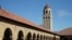 FILE- People walk on the Stanford University campus beneath Hoover Tower in Stanford, Calif., March 14, 2019. 