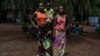 Monique Moukidje, 34 ans, à gauche, avec ses deux enfants Marienne et Odalvia, à Mbangui-Ngoro, le village centrafricain où elle et des centaines d'autres personnes déplacées qui ont fui Bangassou ont trouvé refuge, le 15 février 2021.