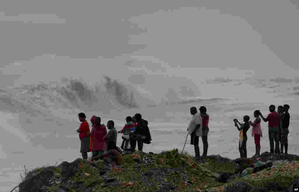 People stand on the coast watching the surf produced by Hurricane Matthew, on the outskirts of Kingston, Jamaica, Oct. 3, 2016.