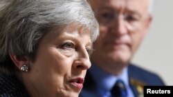 Britain's Prime Minister Theresa May meets with agricultural producers seated next to The Royal Welsh Agricultural Society's chairman John Davies at the Royal Welsh Showground in Builth Wells, Wales, Britain, Nov. 27, 2018. 