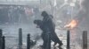 Demonstranti se udaljavaju od suzavca dok se suočavaju s policijom tokom protesta farmera koji pozivaju na veće prihode i zaštitu od strane konkurencije, u blizini zgrade Evropskog parlamenta u Briselu 1. februara 2024.