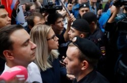 Russian opposition candidate and lawyer at the Foundation for Fighting Corruption Lyubov Sobol, center, and others stand in front of a police line during a protest in Moscow, Russia, July 14, 2019.