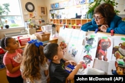 Direktur eksekutif, Maria Isabel Ballivian, mendengarkan siswa memilih karakter favorit PAW Patrol di ACCA Child Development Center, 19 September 2024, Annandale, AS. (John McDonnell/AP)