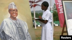 An art student takes part in a competition by drawing a portrait of President-elect Muhammad Buhari, during an art exhibition by Malami Leadership Foundation showcasing portraits of Nigeria's former presidents and heads of state in Abuja, May 27, 2015.