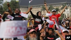 People wear T-shirts with writing that reads "Replace the President in 2019" during a rally in Jakarta, Indonesia, May 6, 2018. 