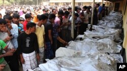 Bangladeshi people identify the bodies of their relatives died in a fire at a garment factory in the Savar neighborhood in Dhaka, Bangladesh, November 25, 2012.