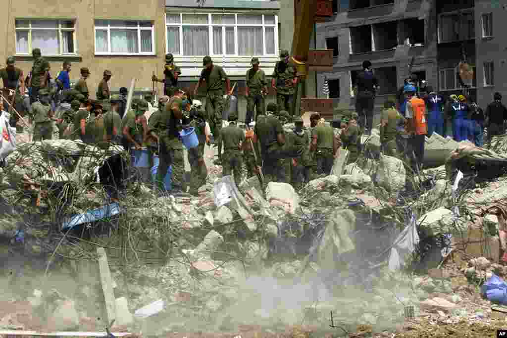 Turkish 3rd Army Corps soldiers attempt to lift rubble from the wreckage of a five-story apartment building in the Avcilar downtown district of Istanbul, August 20, 1999. (Reuters)
