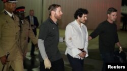 Sam Bankman-Fried, founder and former CEO of crypto currency exchange FTX, is walked in handcuffs to a plane during his extradition to the United States in Nassau, Bahamas Dec. 21, 2022. 