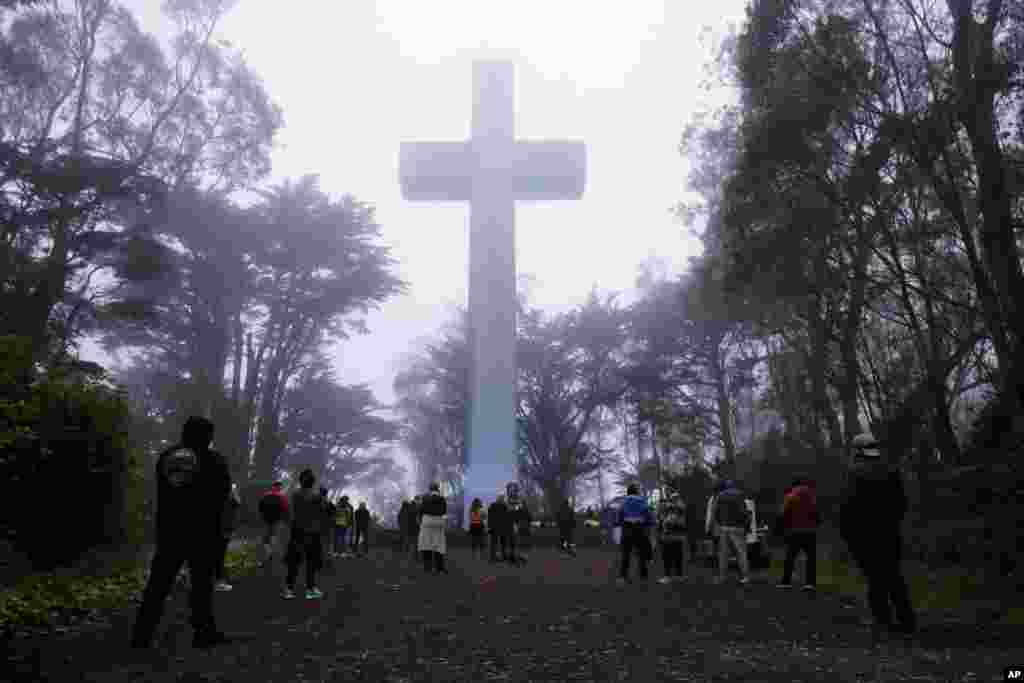 People gather at the Mount Davidson cross in San Francisco, California. Mount Davidson's annual Easter Sunrise Service was canceled for the city's shelter in place orders over coronavirus concerns.