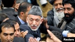 Presiden Afghanistan Hamid Karzai saat meninggalkan pertemuan hari terakhir Loya Jirga. (Reuters/Omar Sobhani)