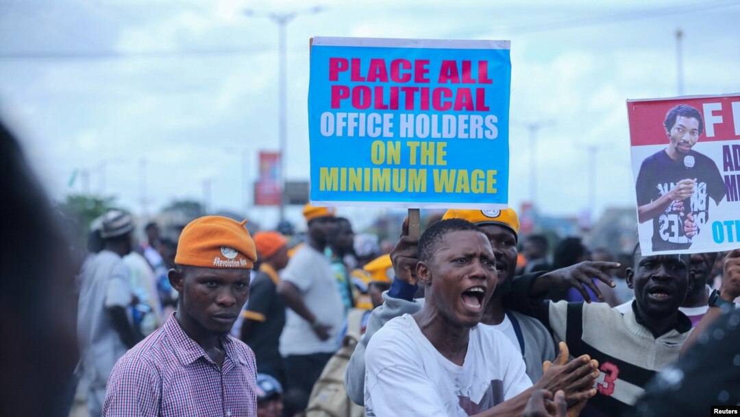 Manifestantes gritam palavras de ordem enquanto participam num protesto ao longo de uma estrada em Lagos.