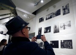 A man takes a cell phone photograph of a wall full of photographs by Robert Frank at the opening of the exhibition featuring his work, "Robert Frank: Books and Films, 1947–2016," at New York University's Tisch School of the Arts, Jan. 28, 2016.