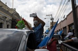 Una mujer participa en una caravana para pedir que el presidente guatemalteco, Alejandro Giammattei, ponga fin a las medidas de confinamiento impuestas desde marzo contra la propagación del nuevo coronavirus. Ciudad de Guatemala 18 de junio de 2020.