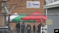Tyson Fresh Meats plant employees line-up outside of the plant, Thursday, April 23, 2020, in Logansport, Ind.