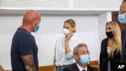 Top Model Israel Bar Refaeli (tengah), mengenakan masker, tiba di pengadilan bersama dengan ayahnya, Raffi (kiri) dan pengacara, di Tel Aviv, Israel, Senin, 20 Juli 2020.