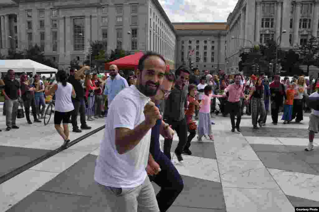 Volunteer Mostafa Hashoun is joined by other participants in a Syrian folk dance called dabke, during Syria Fest in Washington, Sept. 3, 2017. The dance is a mixture of circle and line dancing, and is usually performed at weddings and other joyous occasio