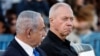 Israeli Prime Minister Benjamin Netanyahu, left, and Israeli Defense Minister Yoav Gallant, right, attend a ceremony for the 70th cohort of military combat officers, at an army base near Mitzpe Ramon, Oct. 31, 2024. 