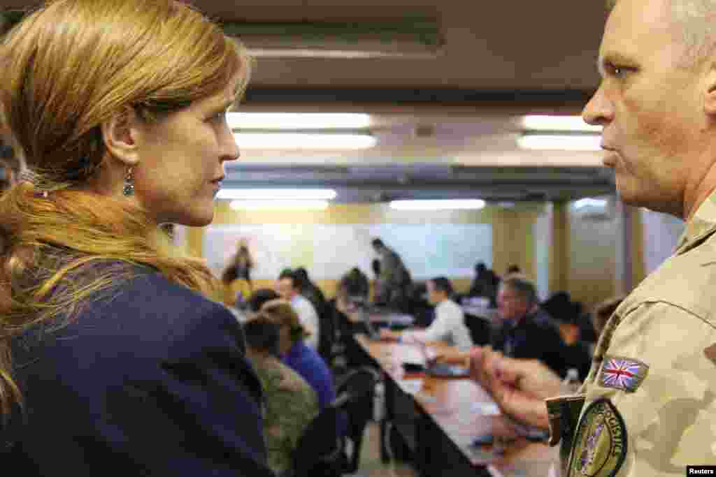 U.S. Ambassador to the United Nations Samantha Power, left, speaks with Group Captain Paul Warwick, chief British military support to the National Ebola Response Center situation room, in Freetown, Sierra Leone, Oct. 27, 2014. 