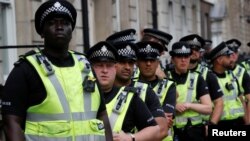 FILE - Police officers stand by during a protest against the visit of U.S. President Donald Trump, in central London, Britain, July 13, 2018. 
