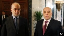 Perdana Menteri Irak, Haider al-Abadi (kanan), bersama Menteri Luar Negeri Irak, Ibrahim al-Jaafari, di kantor Perdana Menteri di Baghdad (21/1). (AP/Hadi Mizban)