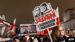 A woman holds a banner reading "Solidarity with Kaminski and Wasik" at a protest in front of the Presidential Palace in Warsaw, Poland, on Jan. 10, 2024. President Andrzej Duda plans to pardon former Interior Minister Mariusz Kaminski and his former deputy, Maciej Wasik.
