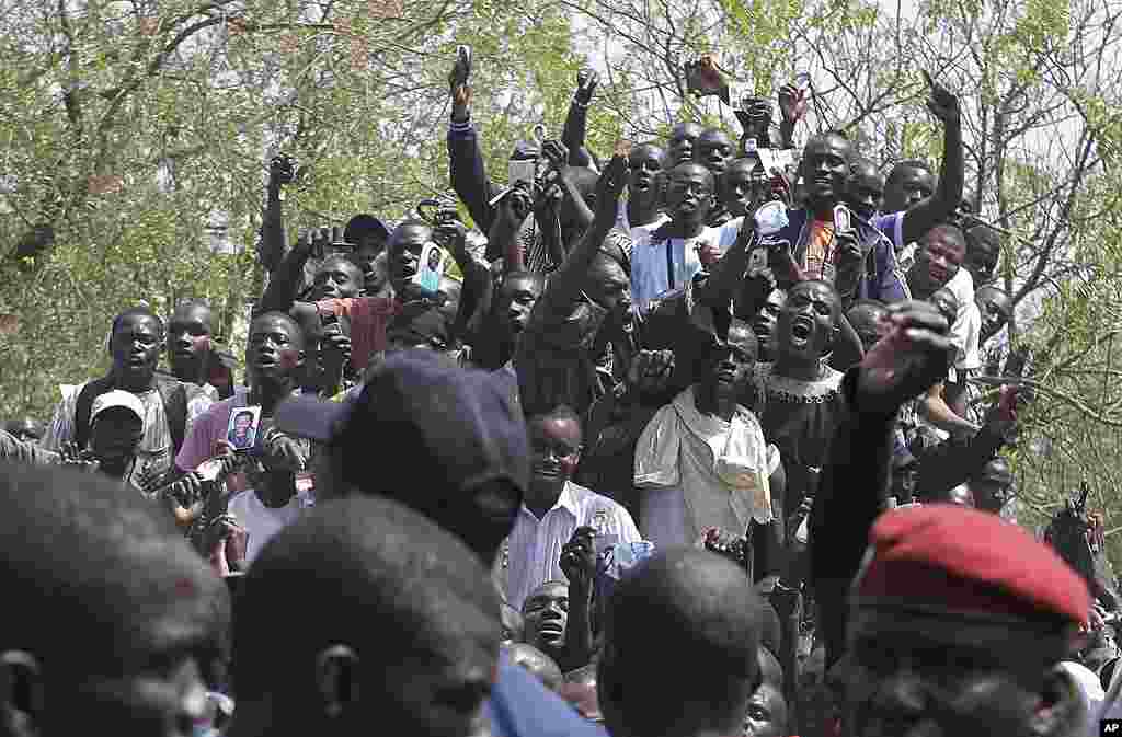 Supporters of Senegalese President Abdoulaye Wade, unseen, cheer outside the polling station where he was voting. (AP) 
