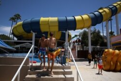 Huéspedes salen de la piscina en un tobogán de agua en el parque acuático Golfland Sunsplash después de que se aliviaron las restricciones de la enfermedad por coronavirus (COVID-19) en Mesa, Arizona, EE. UU., 15 de mayo de 2020.