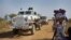 FILE: A United Nations armored vehicle travelling in convoy with a truck passes displaced people walking towards the U.N. camp where they have sought shelter in Malakal, South Sudan. Taken Monday, Dec. 30, 2013.