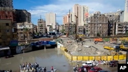 Des Egyptiens sondent le niveau des eaux des inondations après de fortes pluies dans la ville côtière d'Alexandrie, Egypte, 25 octobre 2015. 