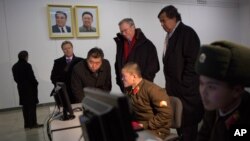 Executive Chairman of Google Eric Schmidt and former governor of New Mexico Bill Richardson look at soldiers working on computers at the Grand Peoples Study House, Pyongyang, North Korea, January 9, 2013.