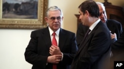 Greek Prime Minister Lucas Papademos (L) speaks with newly appointed Finance minister Philippos Sachinidis in Athens on March 21, 2012.