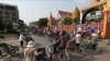 Drivers ride their three-wheeled pedicab along a street in Phnom Penh, Cambodia, Friday, March 27, 2020. (AP Photo/Heng Sinith)