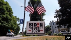 FILE - A car passes a yard displaying a campaign sign for Democratic presidential candidate, former Vice President Joe Biden, June 23, 2020 in North Hampton, New Hampshire.