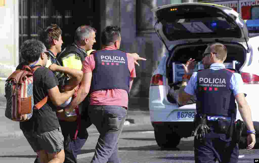 Una persona herida es trasladada a una ambulancia luego de que una furgoneta embistiera a peatones en el histórico distrito de Las Ramblas, en Barcelona, España.