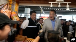 Thai Prime Minister Srettha Thavisin, center right, visits Ploenchit market in Bangkok, Thailand, Aug. 14, 2024.