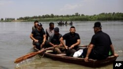 Civilians from western Mosul wait for the ferry to cross the Tigris river as they return to the fully liberated eastern part of the city, Friday, May 5, 2017. Pontoon bridges connecting both sides are closed because of spring flooding. 
