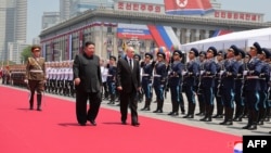Лидер Северной Кореи Ким Чен Ын (в центре слева) и президент России Владимир Путин (в центре Справа) осматривают почетный караул во время церемонии встречи в Пхеньяне, 19 июня 2024 года