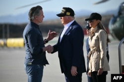 U.S. President Donald Trump, middle, followed by first lady Melania Trump, right, shakes hands with California Governor Gavin Newsom, left, upon arrival at Los Angeles International Airport in Los Angeles, Jan. 24, 2025, to look at how fire devastated much of the region.