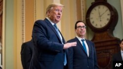 Treasury Secretary Steven Mnuchin listens as President Donald Trump talks to reporters after meeting with Republican lawmakers on Capitol Hill, March 10, 2020, in Washington. 