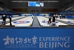 Athletes take part in a curling competition held as a test event for the 2022 Olympic Winter Games, at the National Aquatics Center, in Beijing, China, April 1, 2021.
