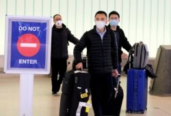 FILE - Passengers arrive at LAX airport from Shanghai, China, before restrictions were put in place to halt the spread of the coronavirus, in Los Angeles, Jan. 26, 2020.