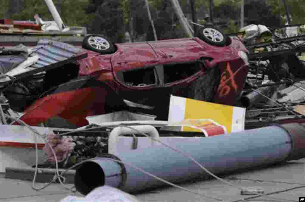 A mangled car is left in front of a Shell gas station in Ringgold, Ga. Thursday, April 28, 2011, after a tornado slammed into several hotels and fast food restaurants on Wednesday. At least five tornadoes were reported in Georgia since the storms began We