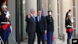 Premye Minis izrayelyen an, Benjamin Netanyahu, agoch, ak Prezidan fransè a, Emmanuel Macron, nan palè Chan Zelize a nan Pari, Frans, dimanch 16 jiyè 2017. 