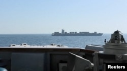 نمایی از کشتی باری "توسکا" با پرچم ایران، در حالی که ناوشکن اسپروئنس در حال انجام عملیات رهگیری و توقف آن در منطقه‌ای در شمال دریای عرب است.