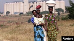 Malawian women walk past empty grain silos in the capital Lilongwe.