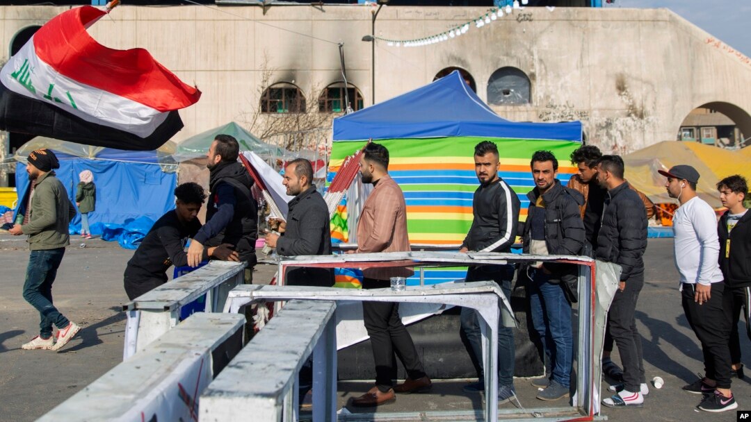 Para pemrotes melewati pos pemeriksaan setibanya di lapangan Tahrir, saat berlangsungnya aksi unjuk rasa di Baghdad, Irak, 25 Desember 2019. (AP Photo/Nasser Nasser)