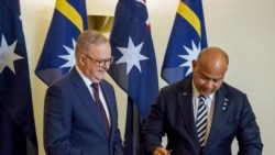 Perdana Menteri Australia Anthony Albanese menyaksikan Presiden Nauru David Adeang, (kanan), menandatangani buku tamu Gedung Parlemen Australia di Canberra, Senin, 9 Desember 2024. (Dominic Giannini/AAP Image via AP)