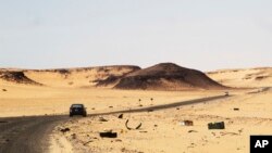 FILE - A car driving along the bandit-plagued road between Sebha and Ubari in southwestern Libya.